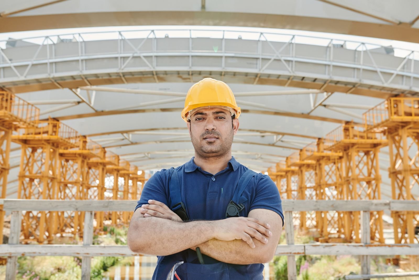 Engineer holding a Stark hard hat in front of a construction site