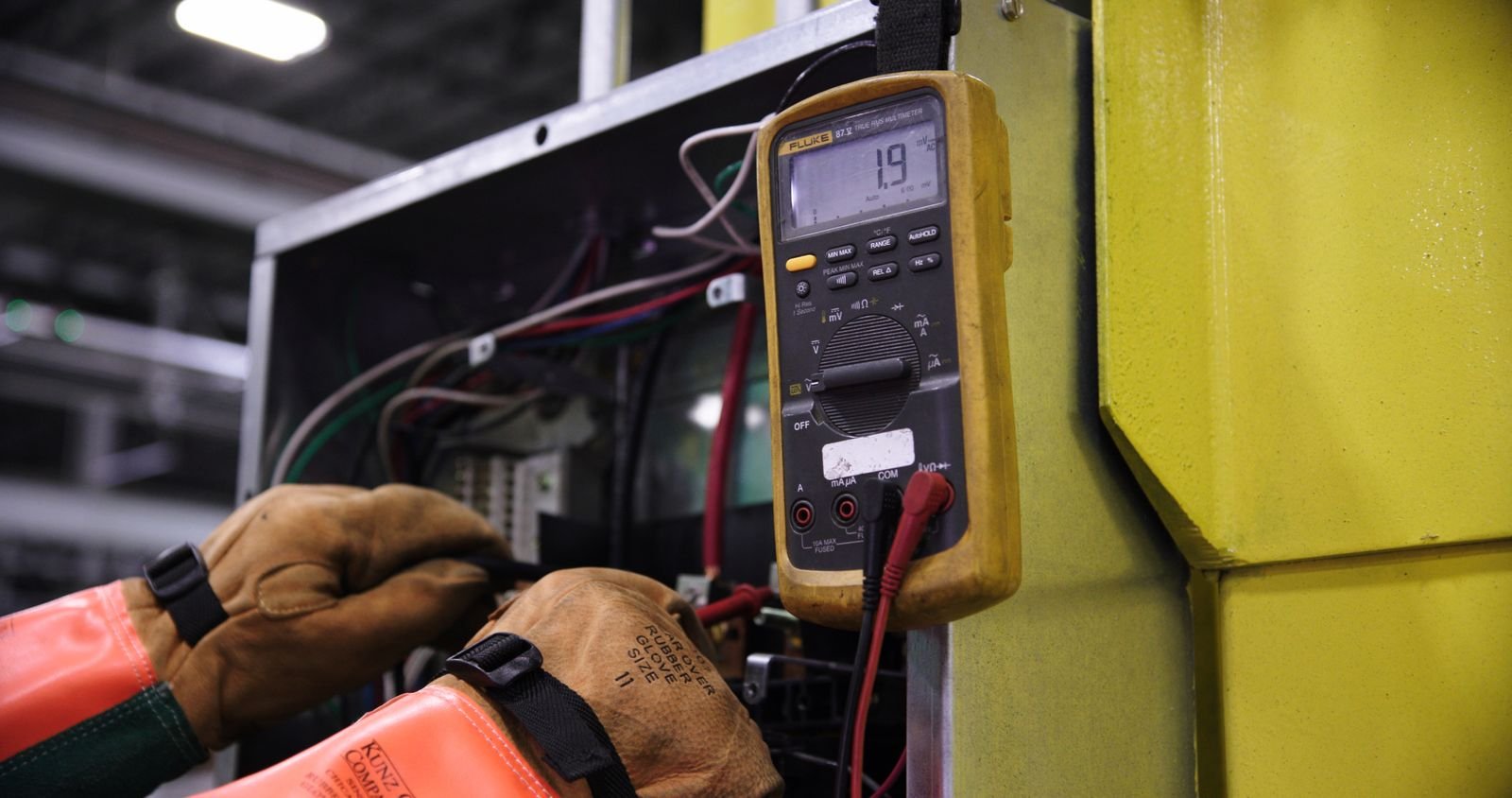 Electrician testing control panel wiring