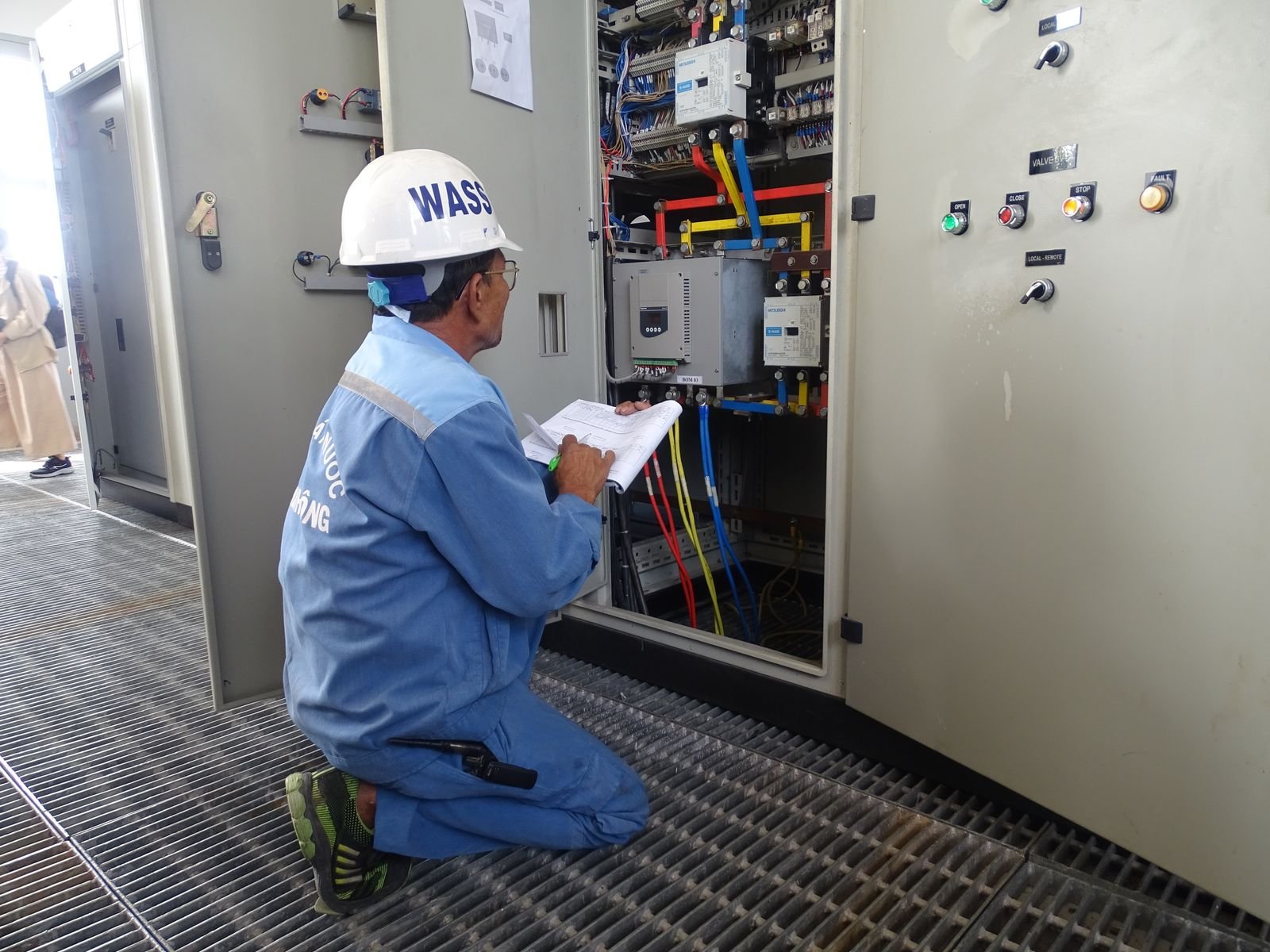 Engineer inspecting an electrical control panel