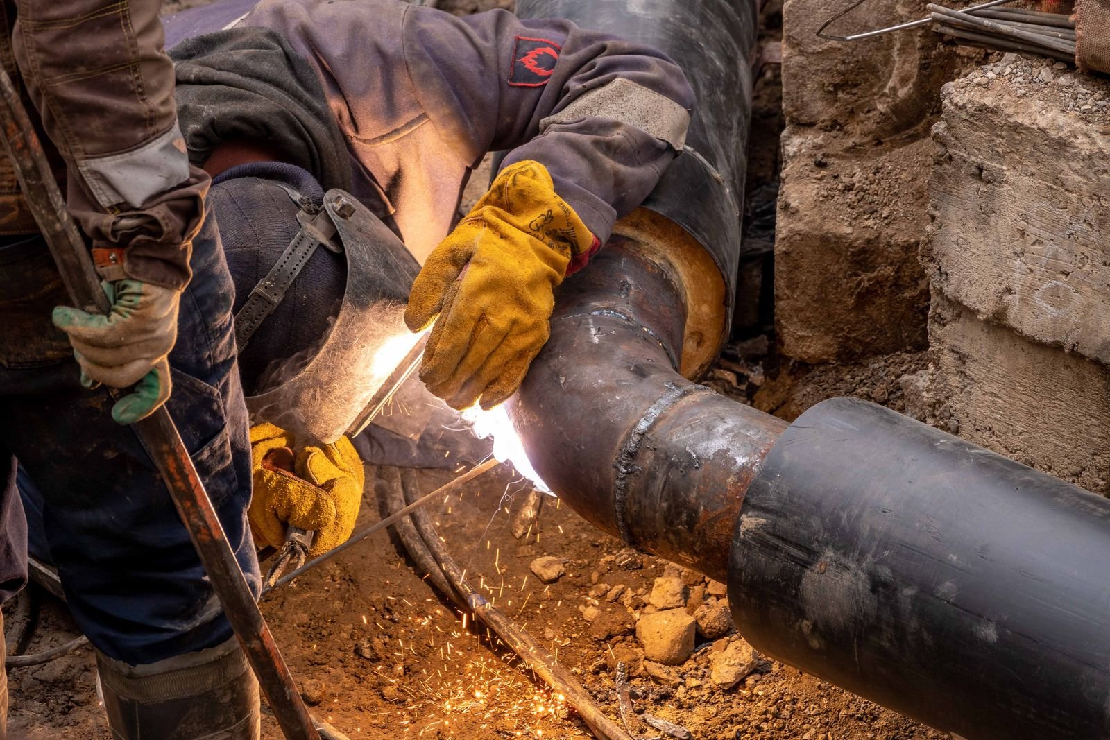 Welder joining steel pipes